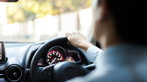 Tânăr șofer conduce la volan un autoturism cu viteză dând pe accelerația de mașină pe drum rutier