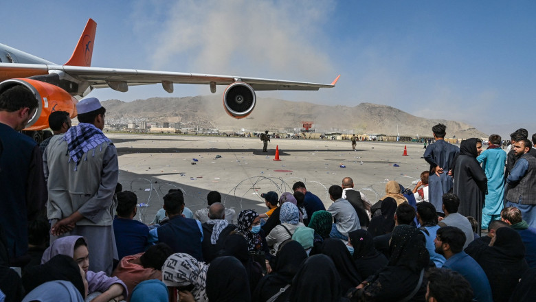 Afgani așteptând să fugă din Afganistan pe aeroportul din KAbul