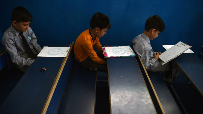 Elevi afgani în școală de educație cu învățământ primar în bănci