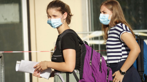 Fete tinere adolescente cu mască de coronavirus COVID-19 SARS-CoV-2 la școală cu educație învățământ și ghiozdane cu cărți