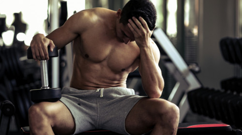 Bărbat supărat, obosit sau frustrat la sală de fitness cu ganteră pentru forță, exerciții fizice sportive