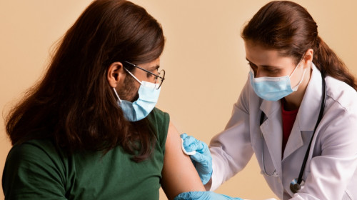 Imunizare cu vaccin anti-COVID-19, SARS-CoV-2 coronavirus, cu seringă și injecție de la medic, doctoriță sau asistentă