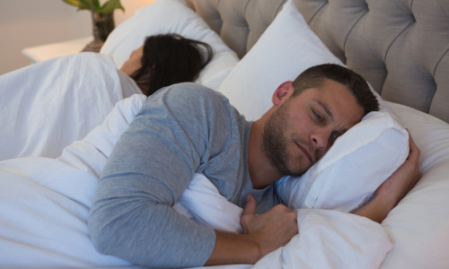 Angry couple avoiding each other in bedroom at home