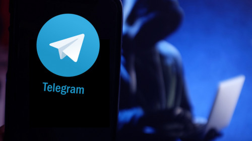 Telegram cu hacker în spate, atacator cibernetic, infractor online pe internet, atac web pe laptop și aplicație de mesagerie