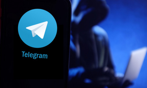 Telegram cu hacker în spate, atacator cibernetic, infractor online pe internet, atac web pe laptop și aplicație de mesagerie