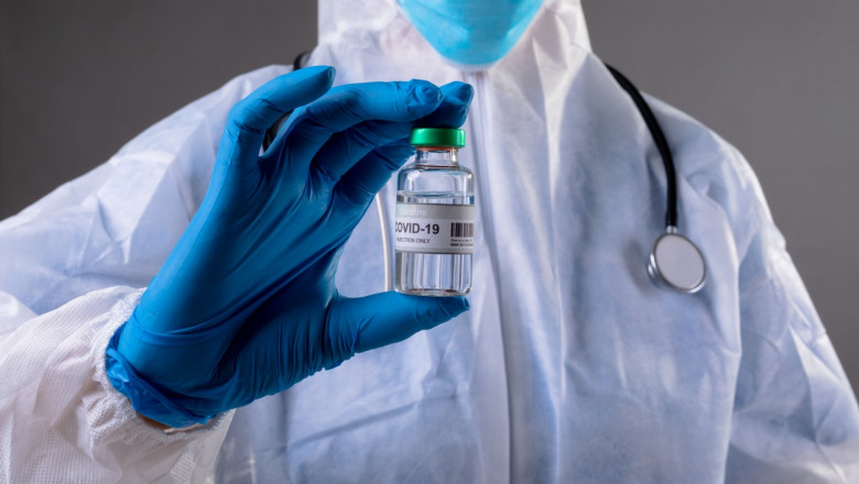 Un medic arată o doză de vaccin anti-COVID.