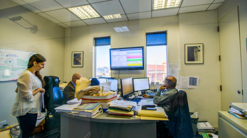 Three office workers at desks in office