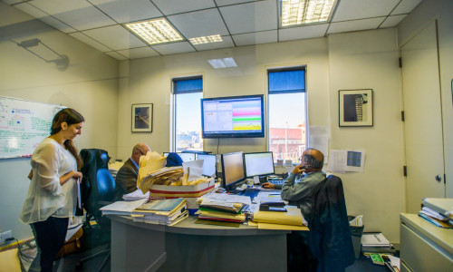 Three office workers at desks in office