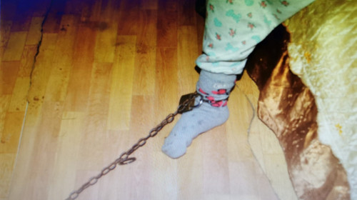 O fetiță de 10 ani, ținută legată cu lanțul în casă de bunica ei