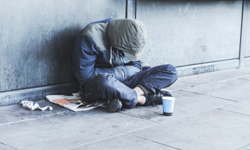 Homeless,Man,Sitting,On,The,Street,In,The,Shadow,Of