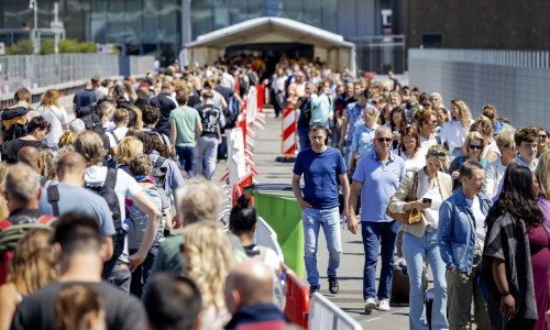 2022-06-03 12:58:36 SCHIPHOL - Travelers while waiting in long lines outside at Schiphol. Travelers are only allowed into the departure halls if their flight departs within four hours. It is again busy with holidaymakers who probably want to take a break