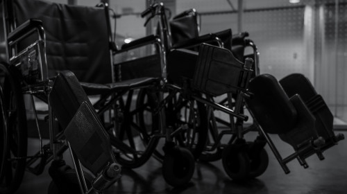 Empty wheelchair in hospital at night for service patient and disabled people. Medical equipment in hospital for assistance handicapped old people. Chair with wheels for patient care in nursing home.