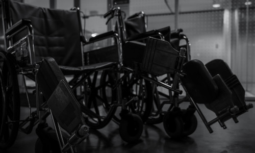 Empty wheelchair in hospital at night for service patient and disabled people. Medical equipment in hospital for assistance handicapped old people. Chair with wheels for patient care in nursing home.