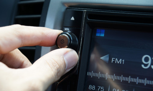 Left,Hand,Adjusting,A,Volume,Control,Knob,Of,The,Car's