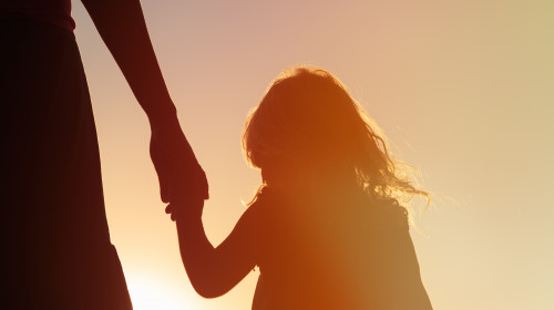 Silhouette,Of,Mother,And,Daughter,Holding,Hands,At,Sunset