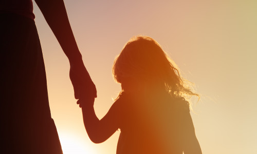 Silhouette,Of,Mother,And,Daughter,Holding,Hands,At,Sunset