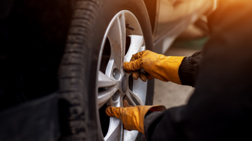 Auto,Mechanic,Man,With,Electric,Screwdriver,Changing,Tire,Outside.,Car