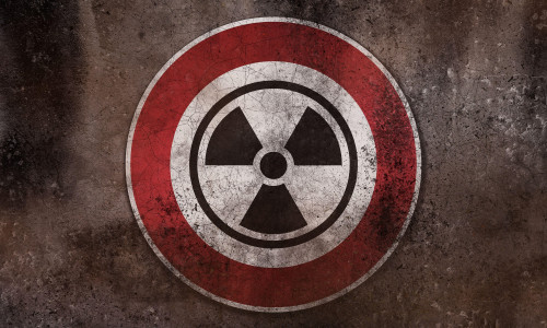 Nuclear Danger Warning Sign On A Wall, Warning Of Radioactivity, Radiation And Nuclear Weapons PHOTOMONTAGE