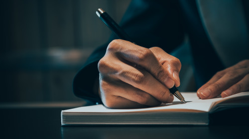 Close,Up,Of,Business,People,Hand,In,Suit,Writing,On