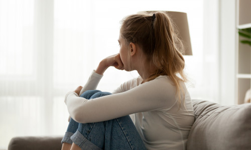 Side,View,Young,Woman,Looking,Away,At,Window,Sitting,On