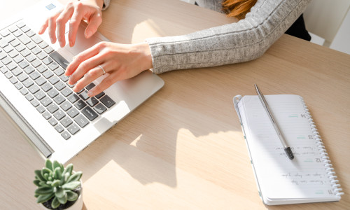 Caucasian,Girl,Typing,On,A,Laptop,At,Her,Desk,In