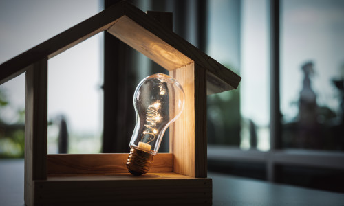 Light,Bulb,With,Wood,House,On,The,Table,,A,Symbol