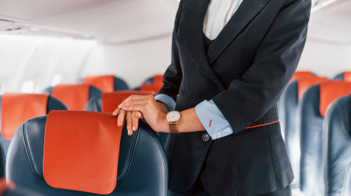 Young,Stewardess,That,Is,In,Formal,Black,Clothes,Is,Standing