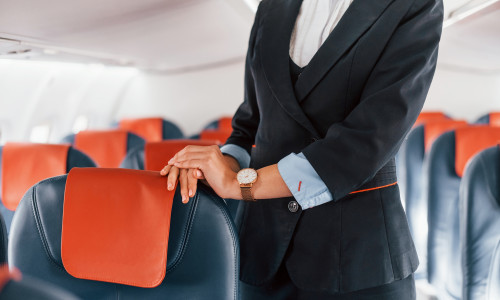 Young,Stewardess,That,Is,In,Formal,Black,Clothes,Is,Standing