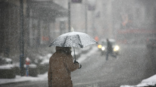 Man,With,Umbrella,During,Snow,Storm,In,The,Street