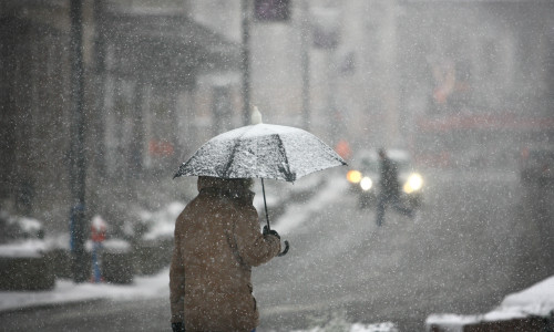 Man,With,Umbrella,During,Snow,Storm,In,The,Street