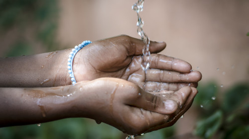 Water,Spilling,Into,Black,African,Children's,Hands,(drought,/,Water