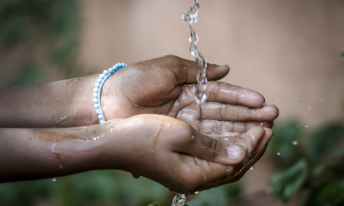 Water,Spilling,Into,Black,African,Children's,Hands,(drought,/,Water