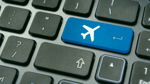online booking of flight ticket, with plane sign on keyboard