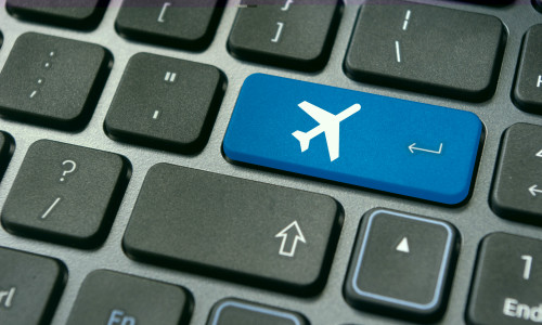 online booking of flight ticket, with plane sign on keyboard