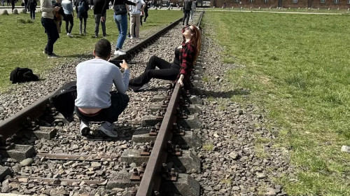 Reacții aprinse în mediul online, după ce o tânără a pozat lasciv pe șinele de tren ce duc în fostul lagăr nazist Auschwitz / Twitter