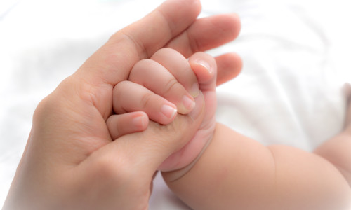 Close-up,Hand,Of,Baby,In,The,Hand,Of,Mother.