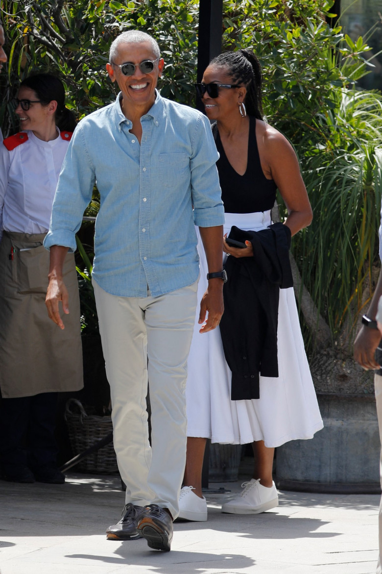 Barack Obama and Michelle Obama walk through Barcelona after visiting the Moco museum and eat with the Spielberg`s.