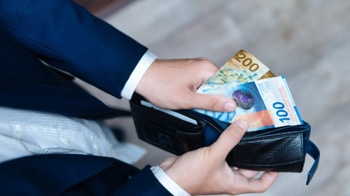 A,Businessman,Holds,A,Wallet,Filled,With,Swiss,Francs,In
