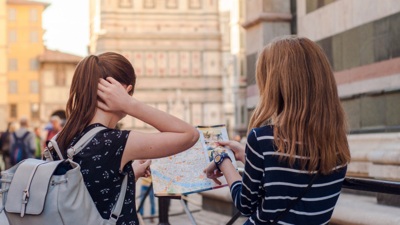Two,Girls,Consulting,A,Map,In,Florence,,Italy