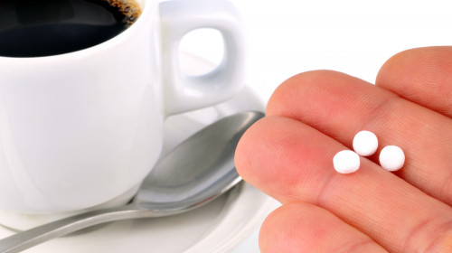 Cup,Of,Coffee,With,Aspartame,Tablets,In,A,Close-up,Hand