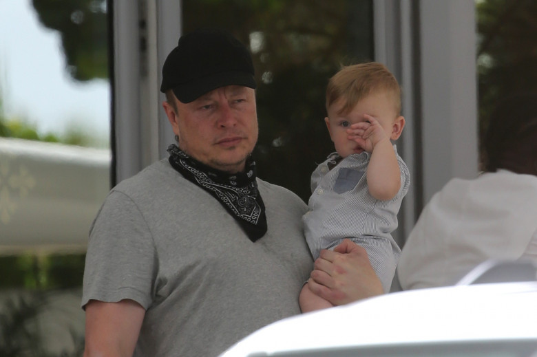 PREMIUM EXCLUSIVE: Elon Musk carries his son "X" as he leaves his hotel with girlfriend Grimes in Miami