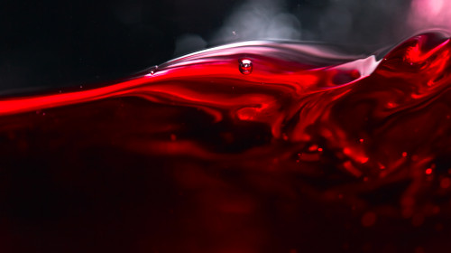 Red,Wine,On,Black,Background,,Abstract,Splashing.