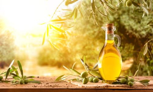 Glass,Container,With,Olive,Oil,On,Wooden,Table,With,Branches