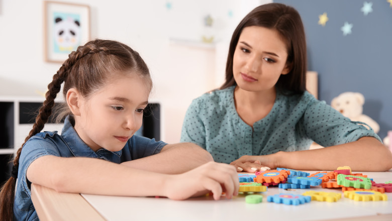 Young,Woman,And,Little,Girl,With,Autistic,Disorder,Playing,At