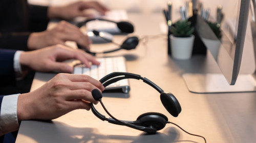 Panorama,Focus,Hand,Holding,Headset,On,Call,Center,Workspace,Desk