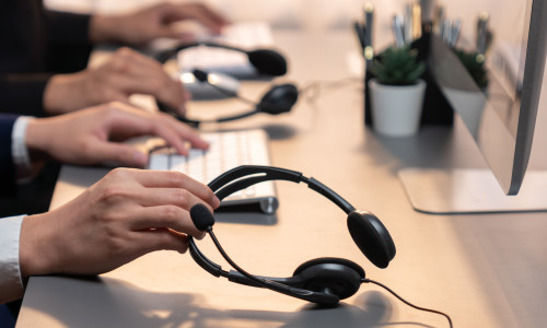 Panorama,Focus,Hand,Holding,Headset,On,Call,Center,Workspace,Desk