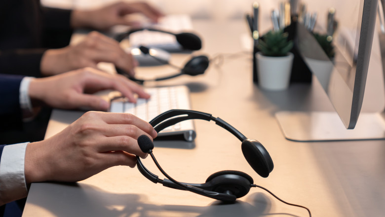 Panorama,Focus,Hand,Holding,Headset,On,Call,Center,Workspace,Desk