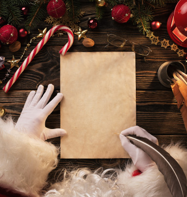 Close,Up,Of,Santa,Claus,Hands,Writing,Letter,On,Worden