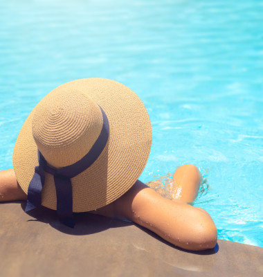 Woman,With,Brown,Hat,Relaxing,In,Swimming,Pool,With,Blue