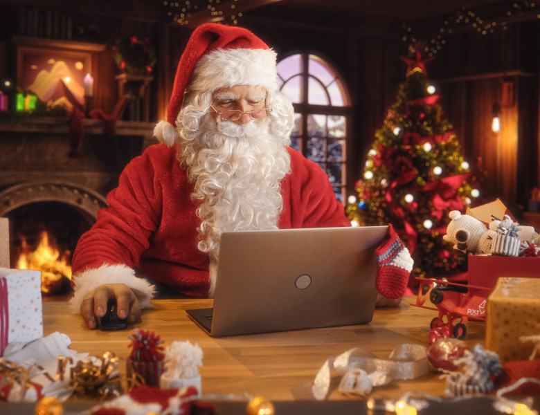 Merry,Santa,Claus,Sitting,Behind,A,Desk,And,Working,On